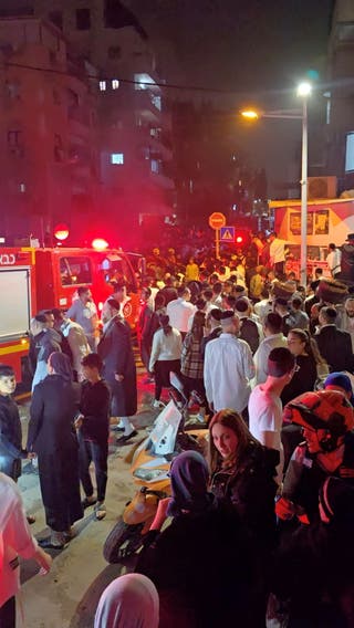 People gather on the street after a missile strike amid the U.S-Israeli conflict with Iran, in Bnei Brak, Israel